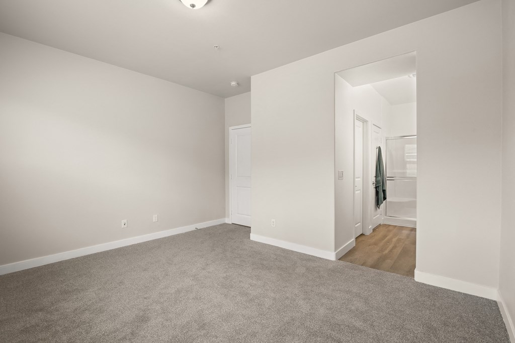 a living room with carpet and a door to a bathroom