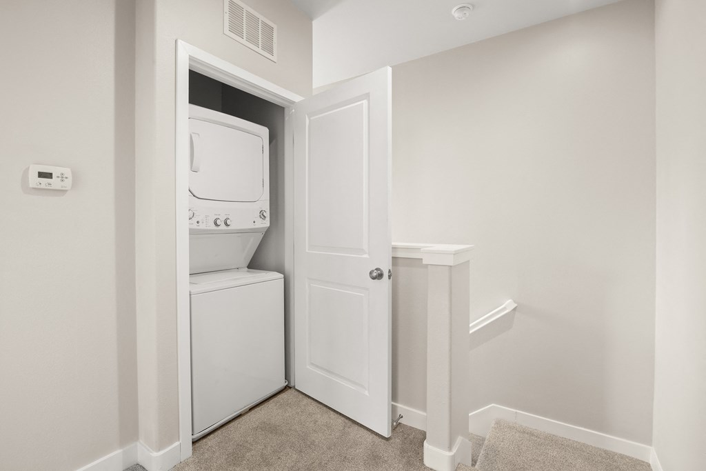 a laundry room with a washer and dryer and a white door