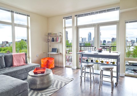 a living room with a couch and a bar and a view of the city