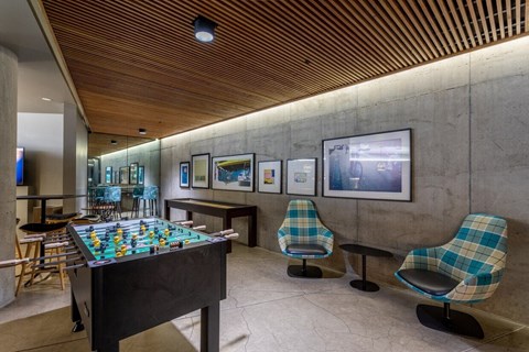 a game room with a foosball table and chairs