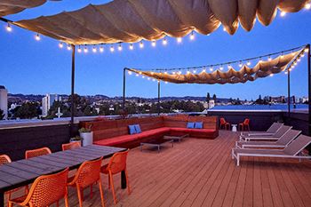 a rooftop deck with couches and tables and chairs