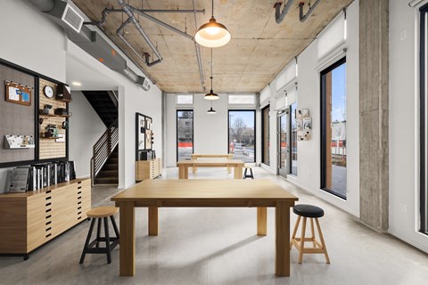 A modern room with a long table and stools.