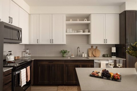 A kitchen with white cabinets and a wooden island.