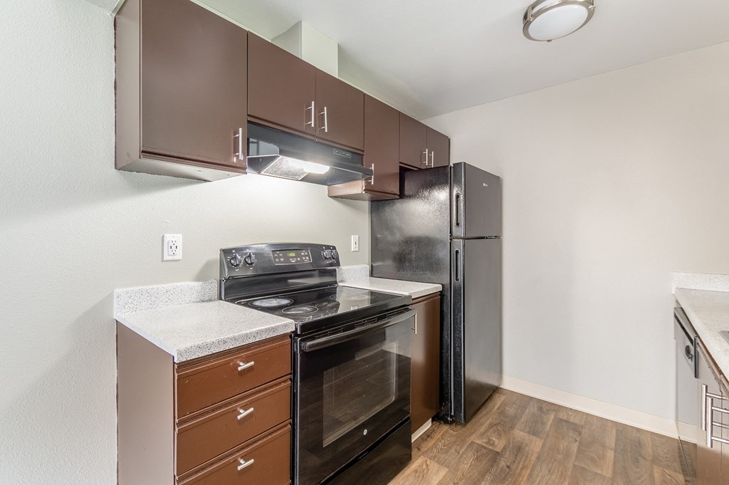 a kitchen with brown cabinets and stainless steel appliances