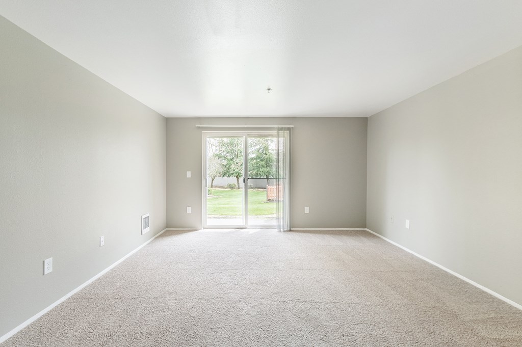 an empty room with a door leading to a yard