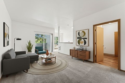 A living room with a grey carpet and a wooden floor.