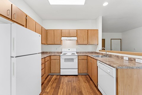 A kitchen with wooden cabinets and white appliances.