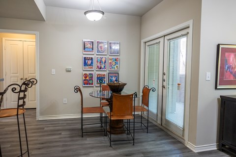 A dining room with a table set for four.