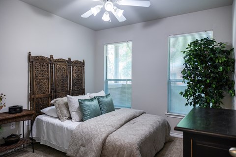 A bedroom with a large bed and a wooden headboard.