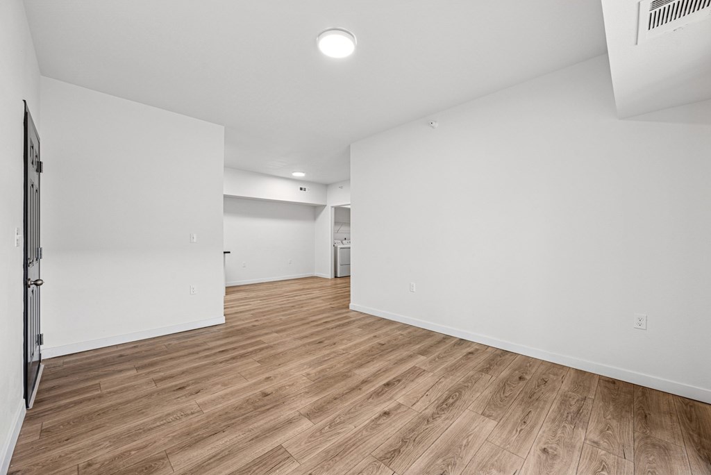 A room with wooden flooring and white walls.