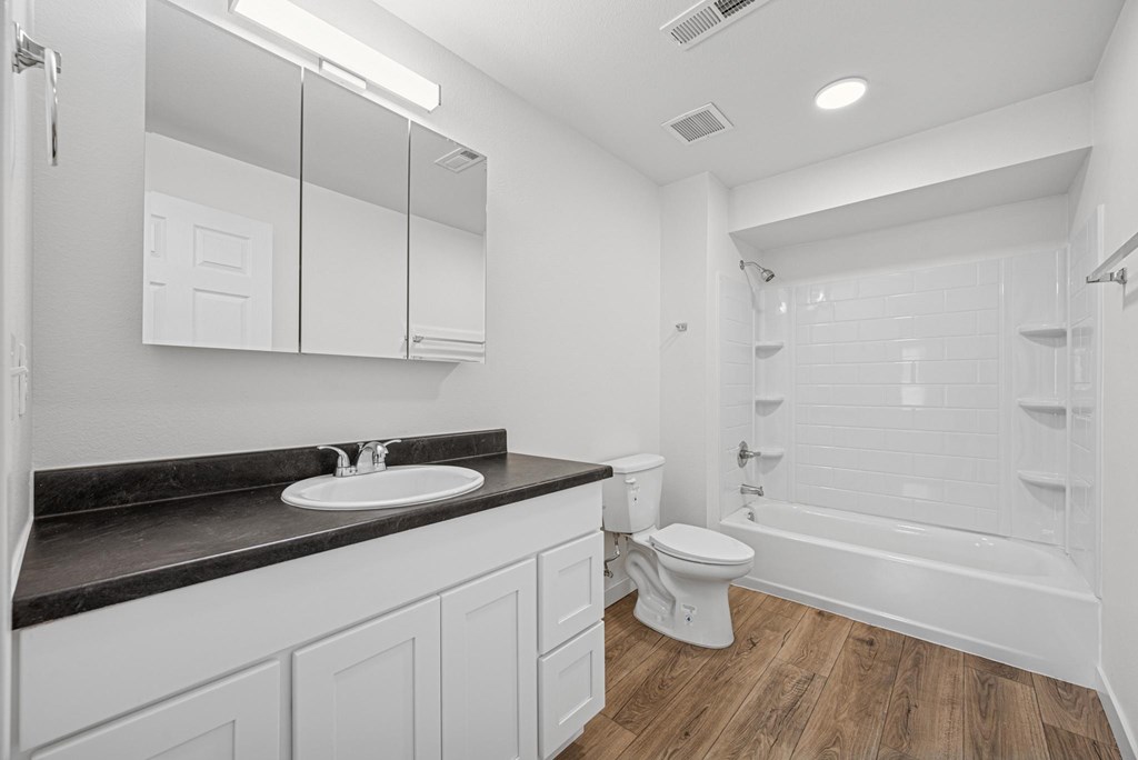 A white bathroom with a sink, toilet, and bathtub.