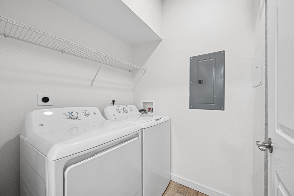A white washing machine and dryer in a small laundry room.
