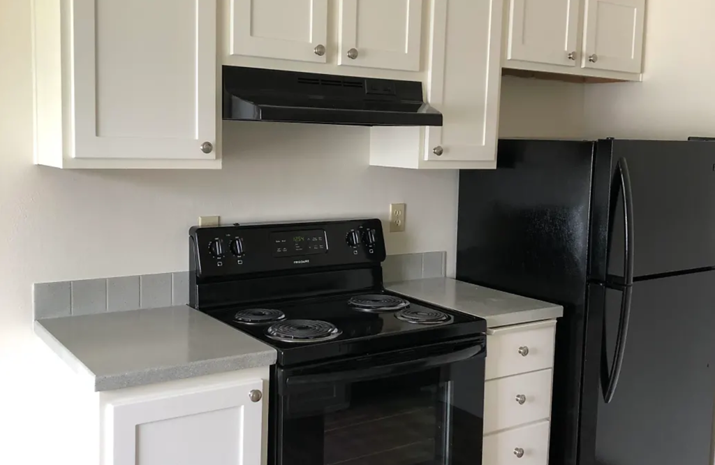 a kitchen with black appliances and white cabinets