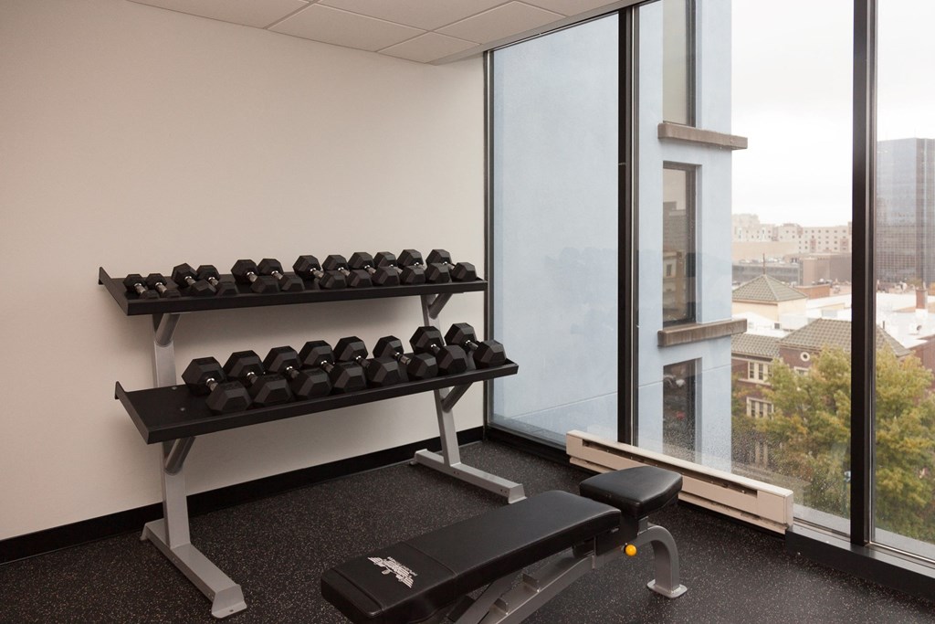 a fitness room with weights and a window