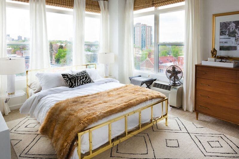 a bedroom with a bed and large windows