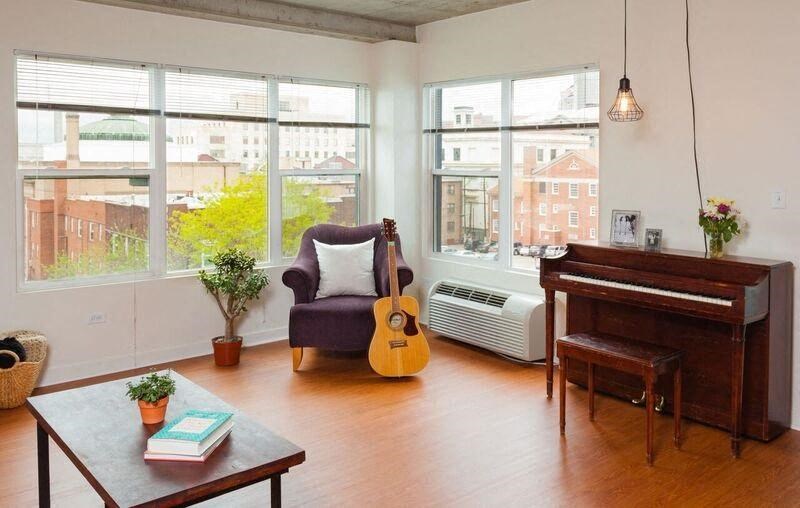 a living room with a guitar and a piano
