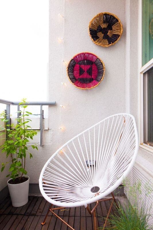 a white chair on a balcony with a fan