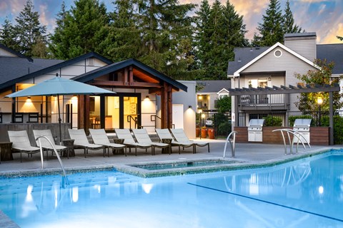 a swimming pool with lounge chairs next to a house