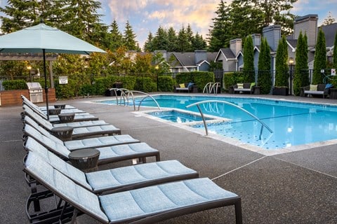 a swimming pool with a row of lounge chairs next to it