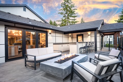 a patio with two couches and a fire pit