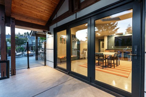 a patio with sliding glass doors and a dining area with a table and chairs