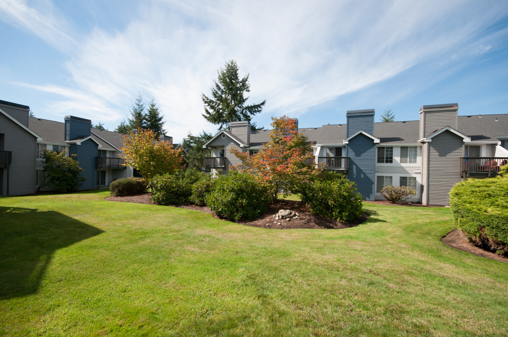 Silverdale WA Apartments - Exterior View of Ridgetop Apartment Building Showcasing Beautiful Green Landscaping