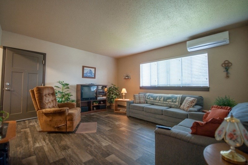 A living room with a brown chair and a grey couch.