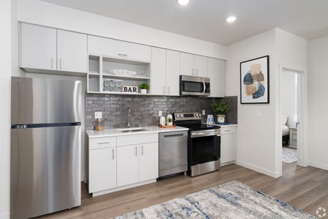 A modern kitchen with a refrigerator, oven, and microwave.