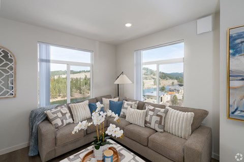 A living room with a couch, a coffee table, and a large window.
