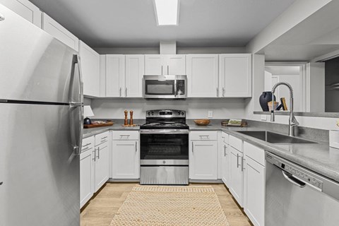 a kitchen with stainless steel appliances and white cabinets
