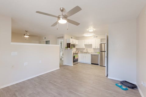 A kitchen with a refrigerator, sink, and cabinets is visible through an open door.