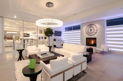 a living room with white furniture and a clock on the wall