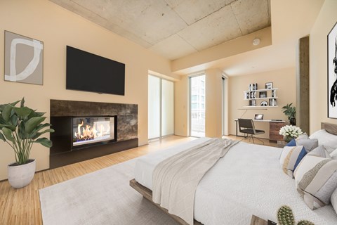 A modern bedroom with a large bed and a fireplace.