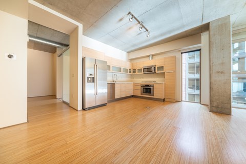 A kitchen with wooden floors and stainless steel appliances.
