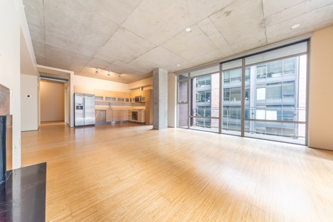 A spacious room with wooden floors and a high ceiling.