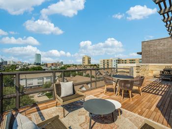 a balcony with a table and chairs and a view of the city