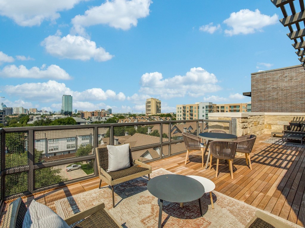 a balcony with a table and chairs and a view of the city