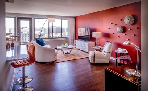 A living room with a red wall and a white chair.