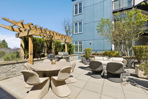 A patio with a table and chairs and a pergola.