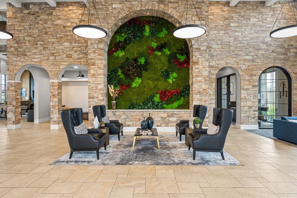 the lobby of a hotel with a large wall mural of plants in a lobby