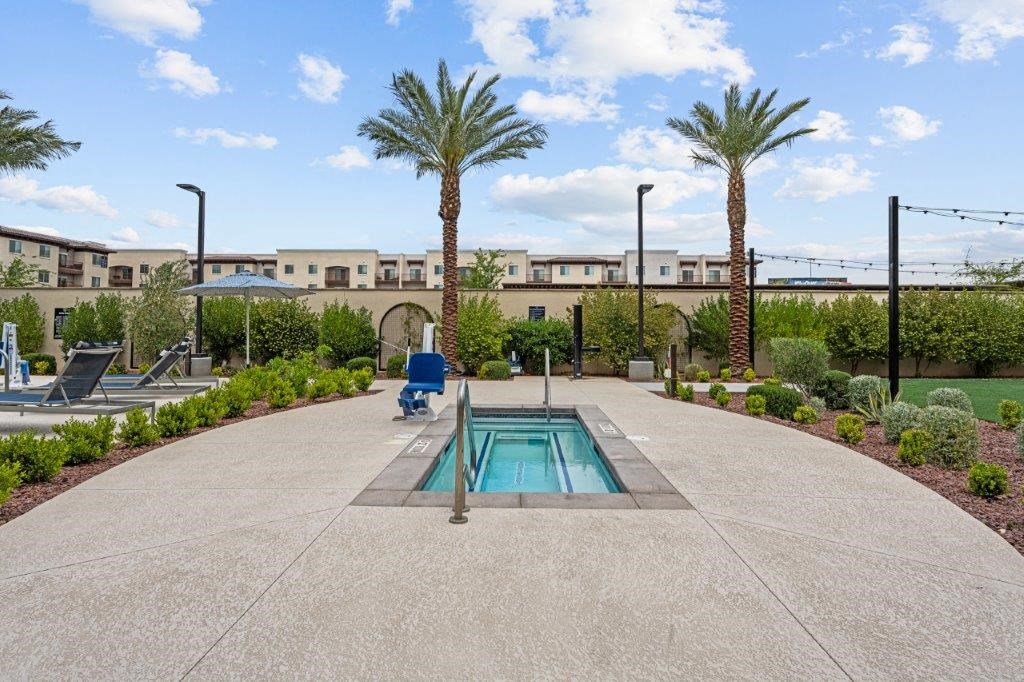 a small pool sits in the middle of a patio with palm trees