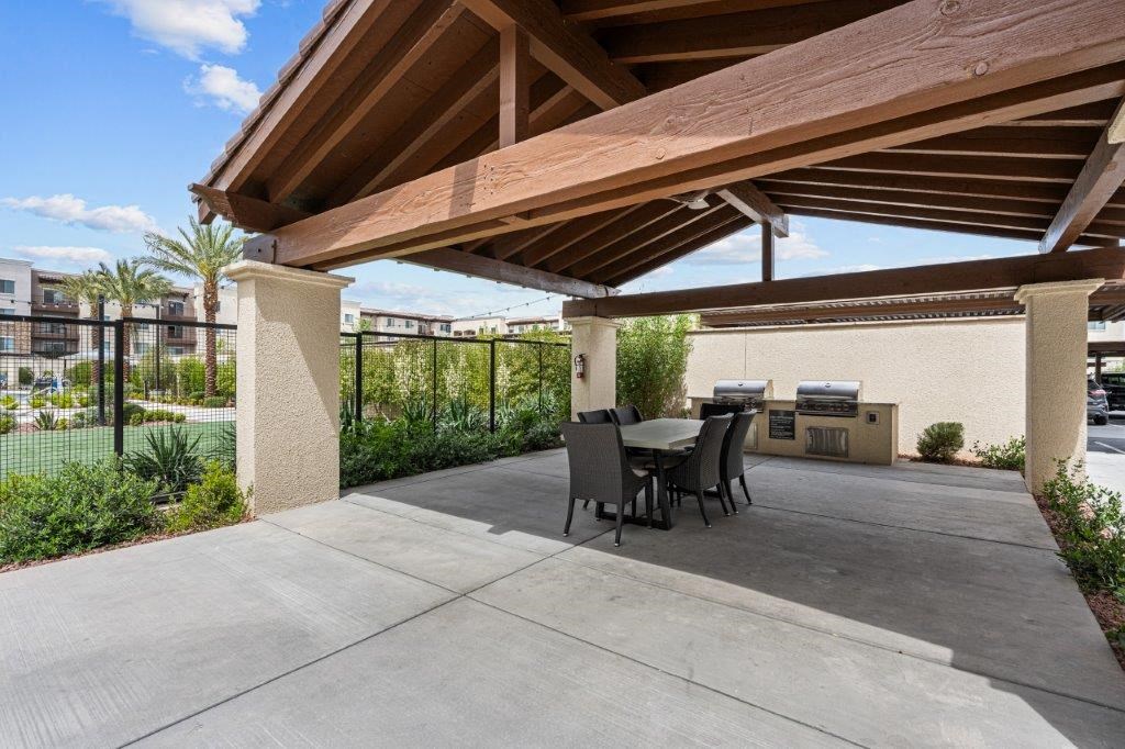 a covered patio with a table and chairs
