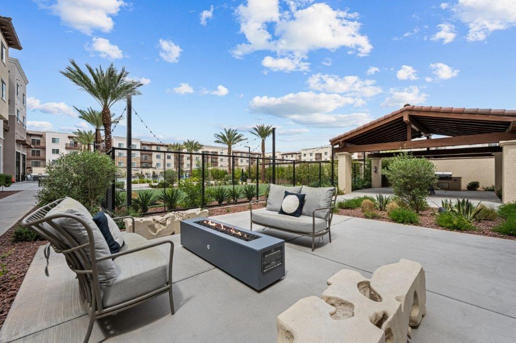a patio with chairs and a fire pit