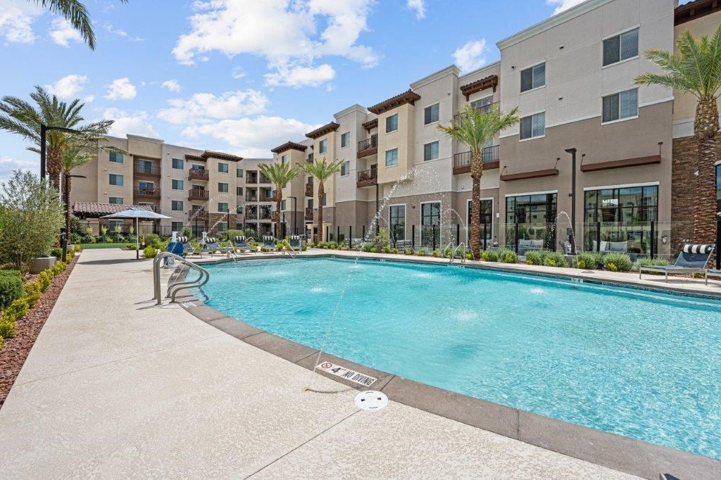 a swimming pool with an apartment building in the background