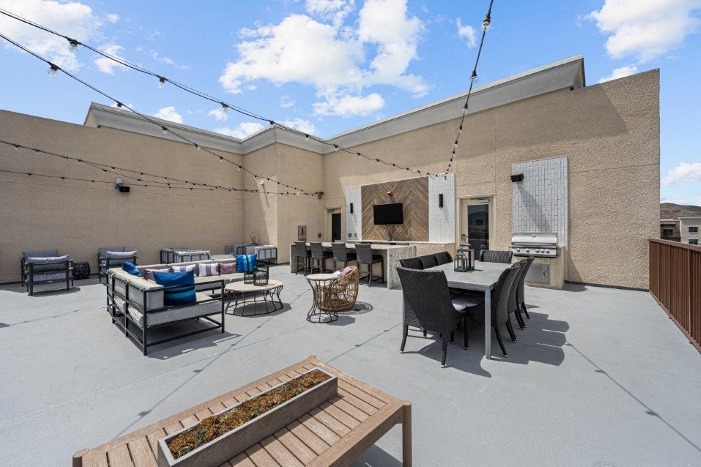 the patio of the building has a table and chairs and a fireplace
