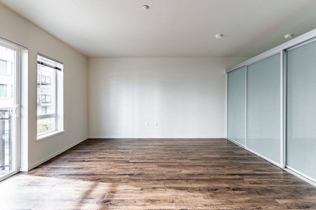 an empty living room with glass doors and a wood floor