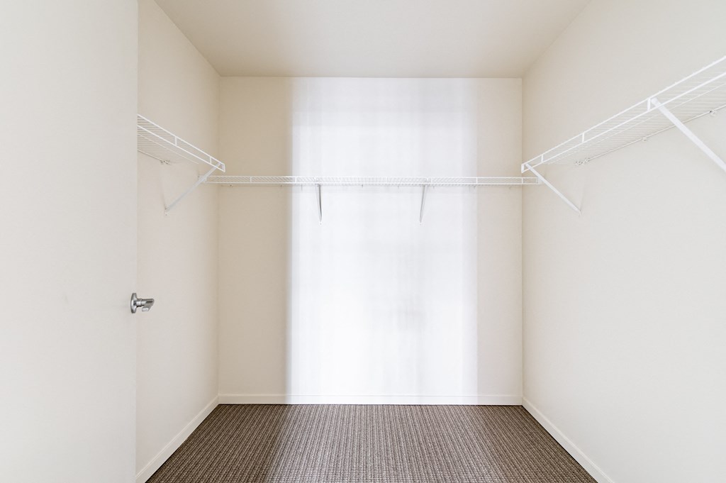 an empty room with white walls and a window with white curtains