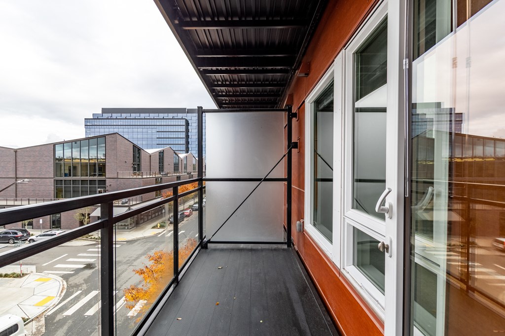 a balcony with a view of a city and a glass door