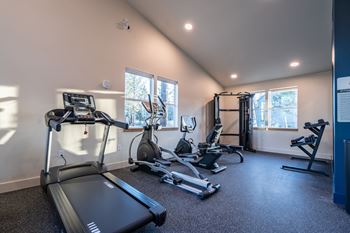 A well-equipped home gym with a treadmill, stationary bike, and other exercise machines.