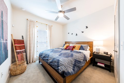 Lenox SoCo Apartments  bedroom with a bed and a ceiling fan